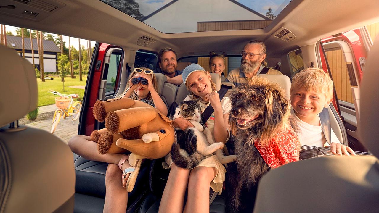 Eine Familie mit Hund und Katze auf den Rückbänken eines Volkswagen Multivans.