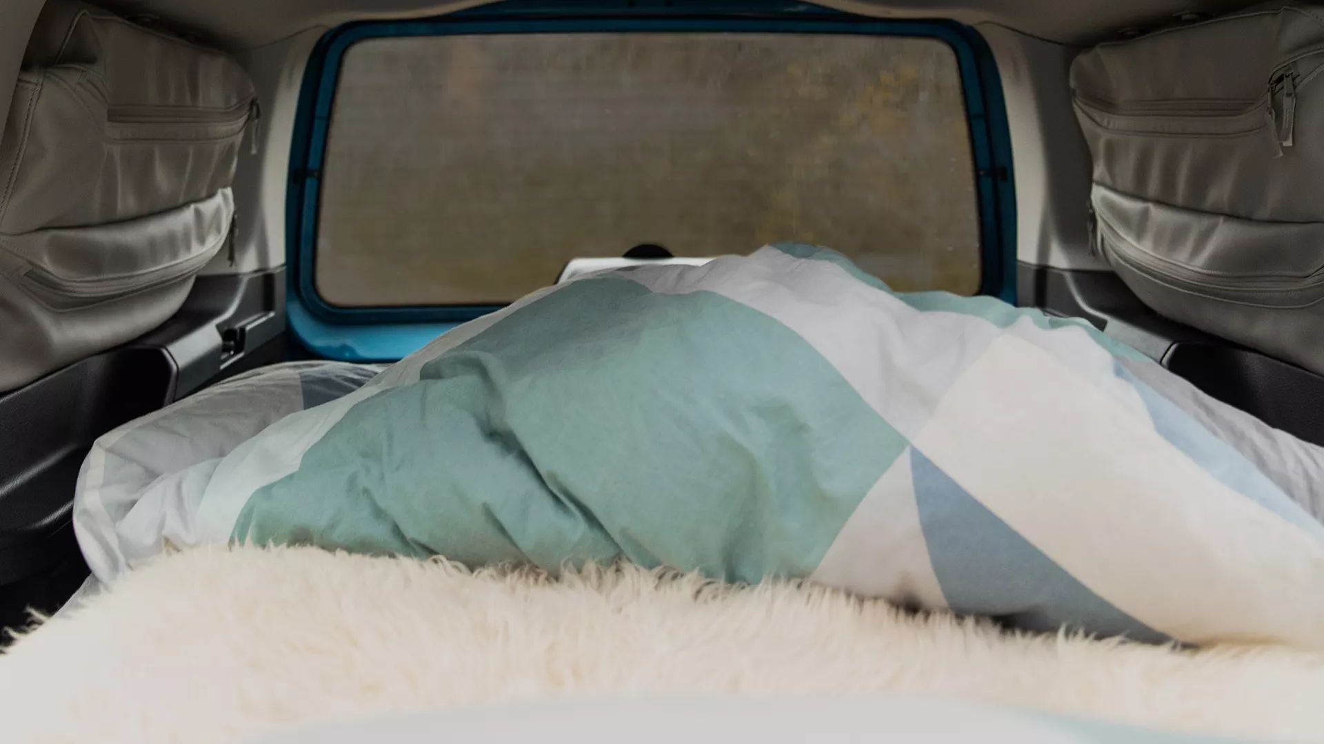 VW Caddy California verdunkelte Scheibe mit Innenraum und bezogenem Bett 