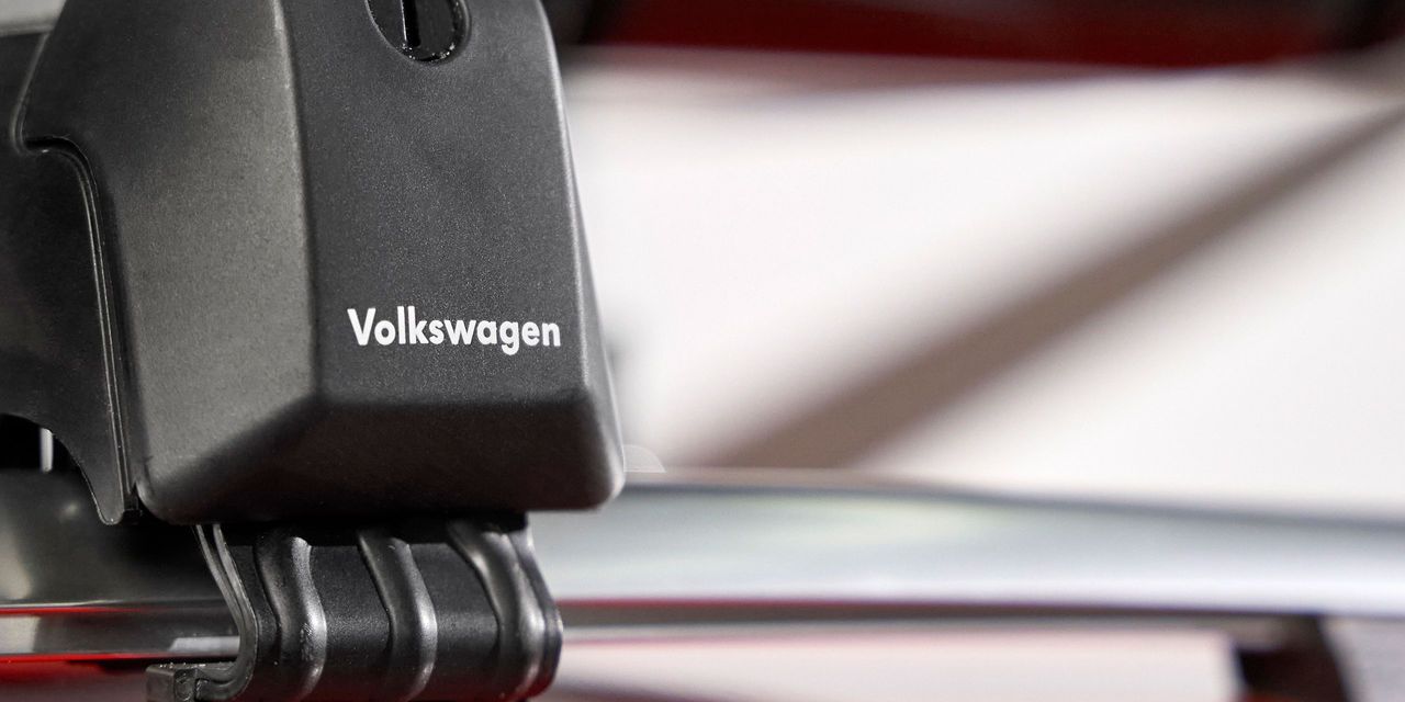 Nahaufnahme eines schwarzen Dachgepäckträgers mit Volkswagen-Logo auf einer silbernen Reling.