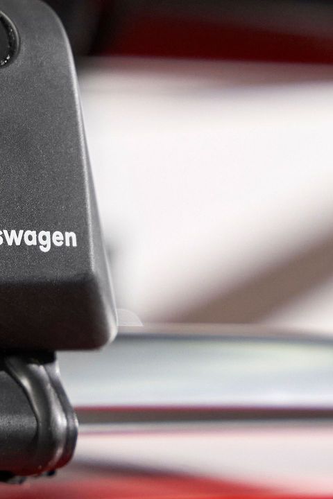 Nahaufnahme eines schwarzen Dachgepäckträgers mit Volkswagen-Logo auf einer silbernen Reling.