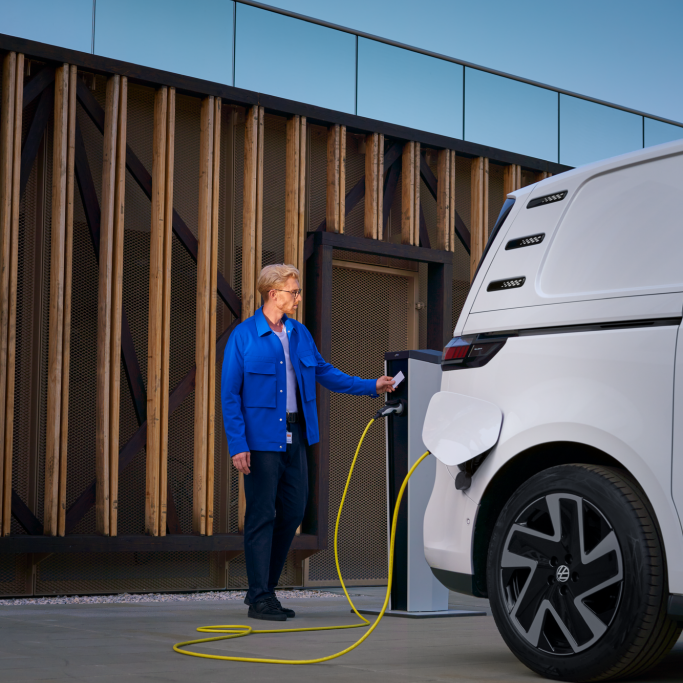 Ein Mann lädt einen Volkswagen ID. Buzz an einer Ladesäule.