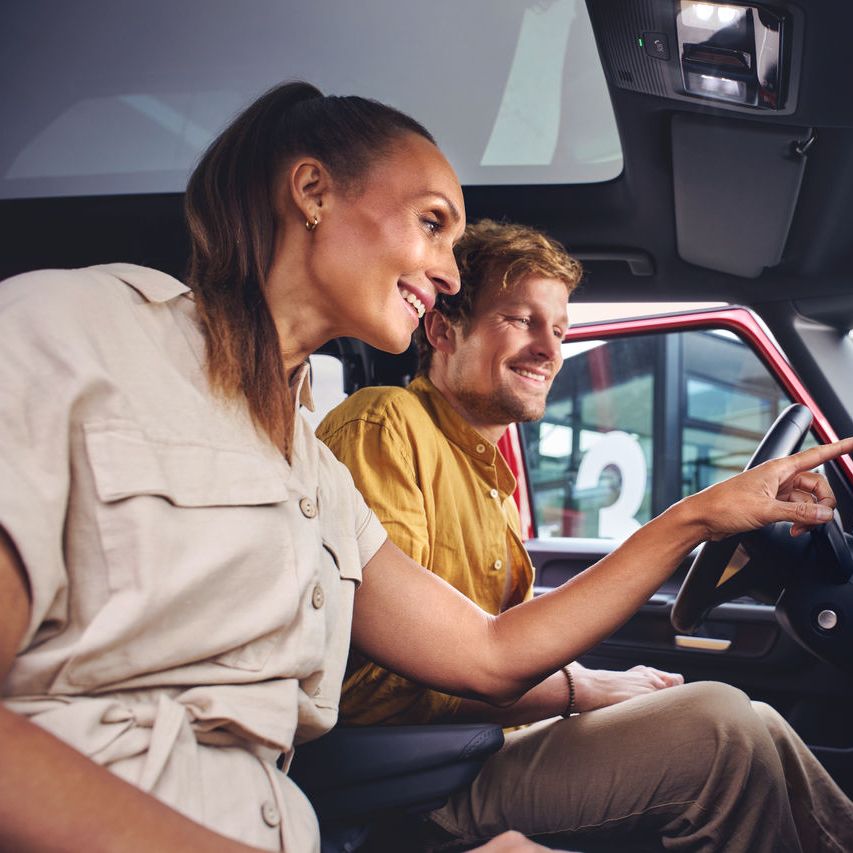 Ein Mann und eine Frau sitzen in einem Volkswagen Nutzfahrzeug und entdecken die Funktionen auf dem Touch Display.