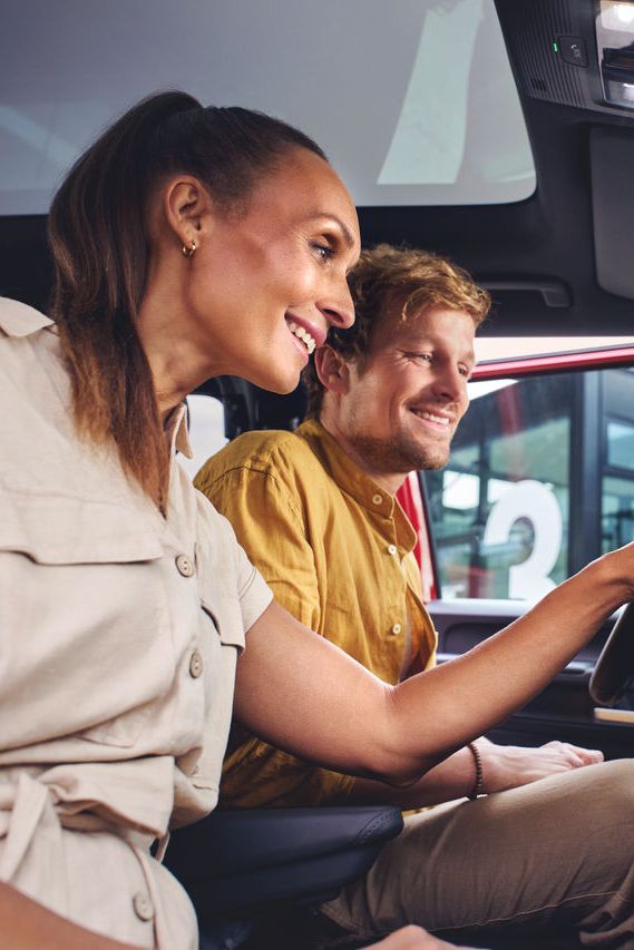 Ein Mann und eine Frau sitzen in einem Volkswagen Nutzfahrzeug und entdecken die Funktionen auf dem Touch Display.