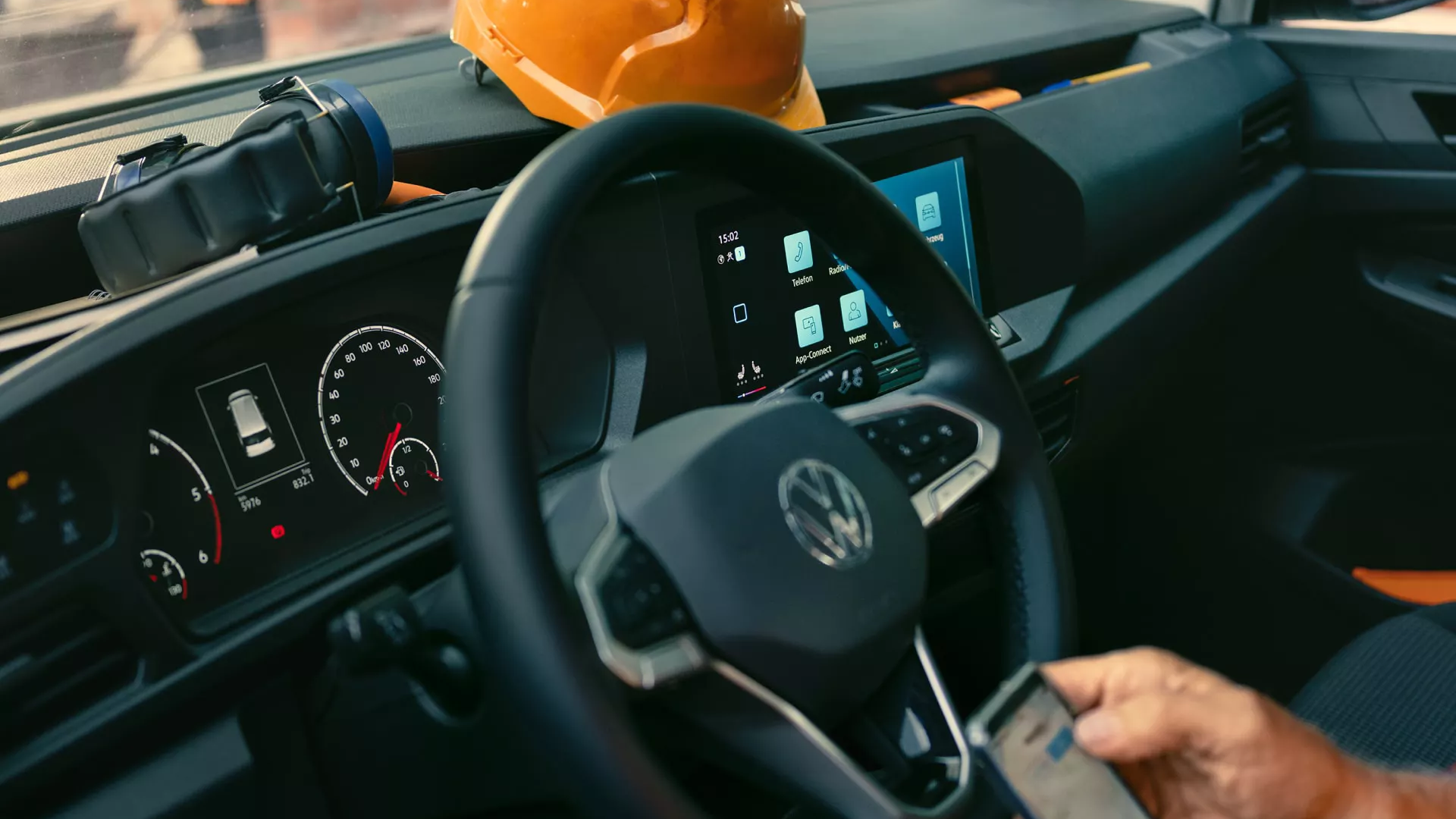 Innenansicht Caddy Cargo, Fahrer verbindet sein Smartphone mit dem Auto