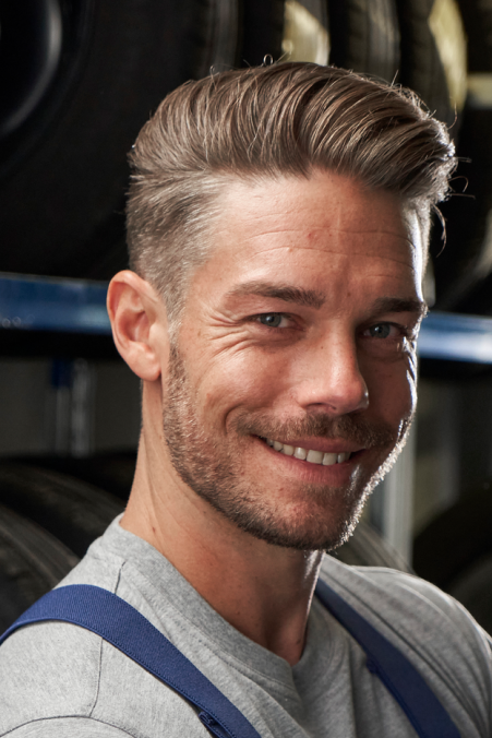 Ein VW Techniker vor Regalen mit Volkswagen Reifen und Rädern