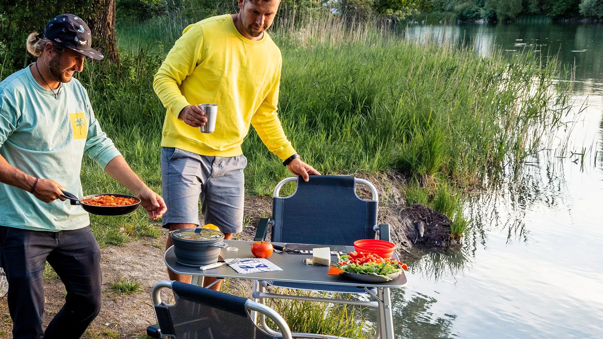 VW Caddy California 2 Personen Kochen und Essen auf ihren Campingtisch am See