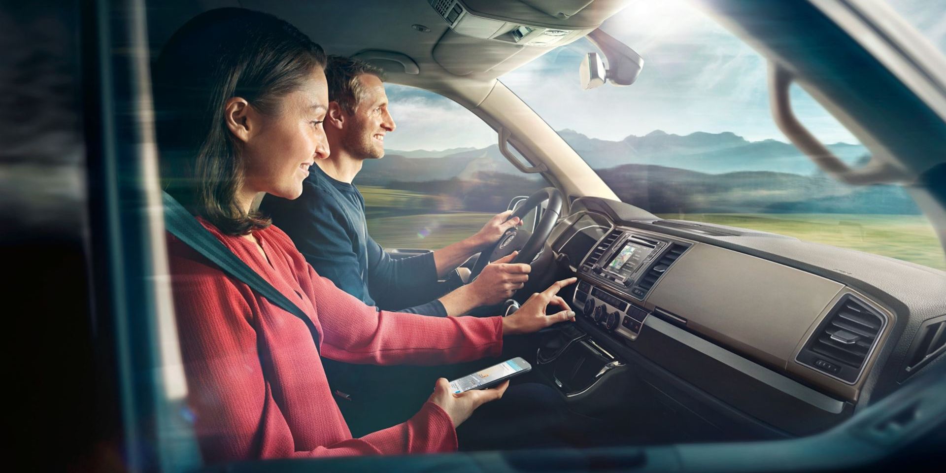 Ein Pärchen sitzt im Cockpit in einem VW-Nutzfahrzeug