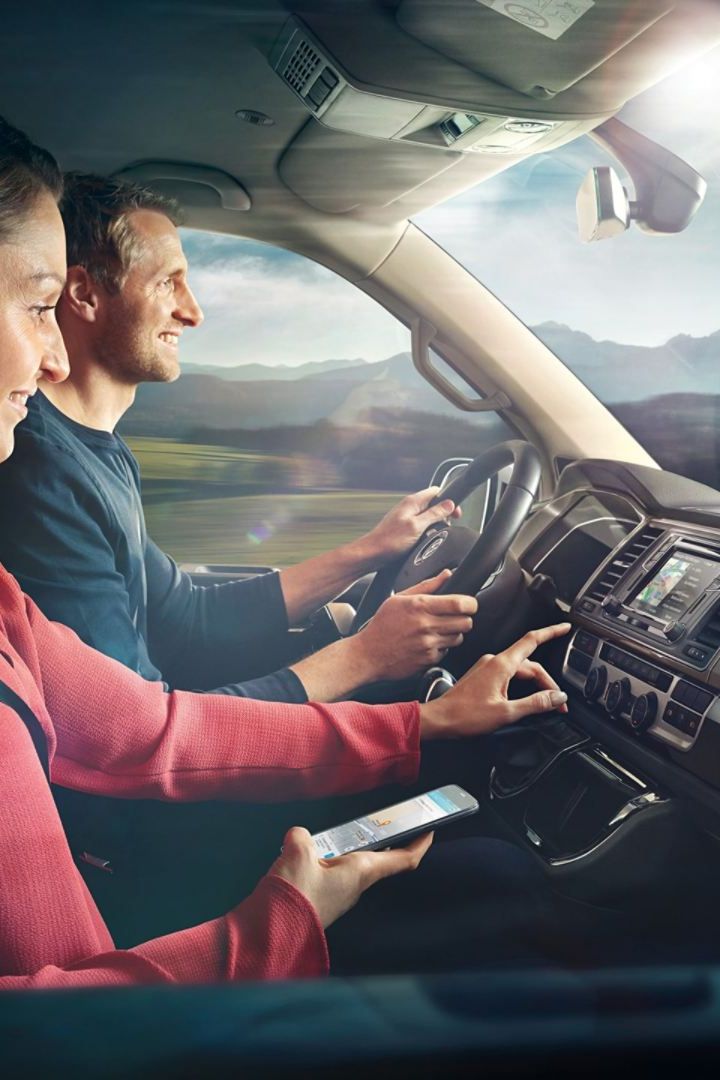 Ein Pärchen sitzt im Cockpit in einem VW-Nutzfahrzeug