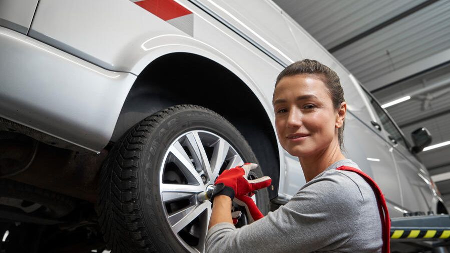 Eine Volkswagen Technikerin beim Reifenwechsel