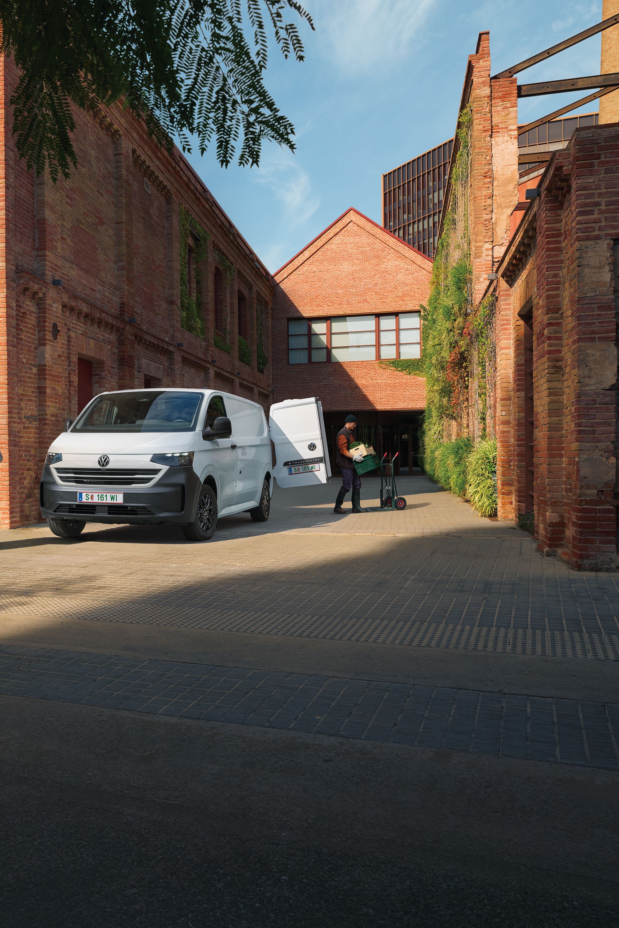 VW Transporter Kastenwagen in Weiß steht vor Haus