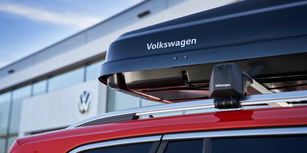 Eine schwarze Dachbox mit Volkswagen Schriftzug am Dach eines Volkswagen