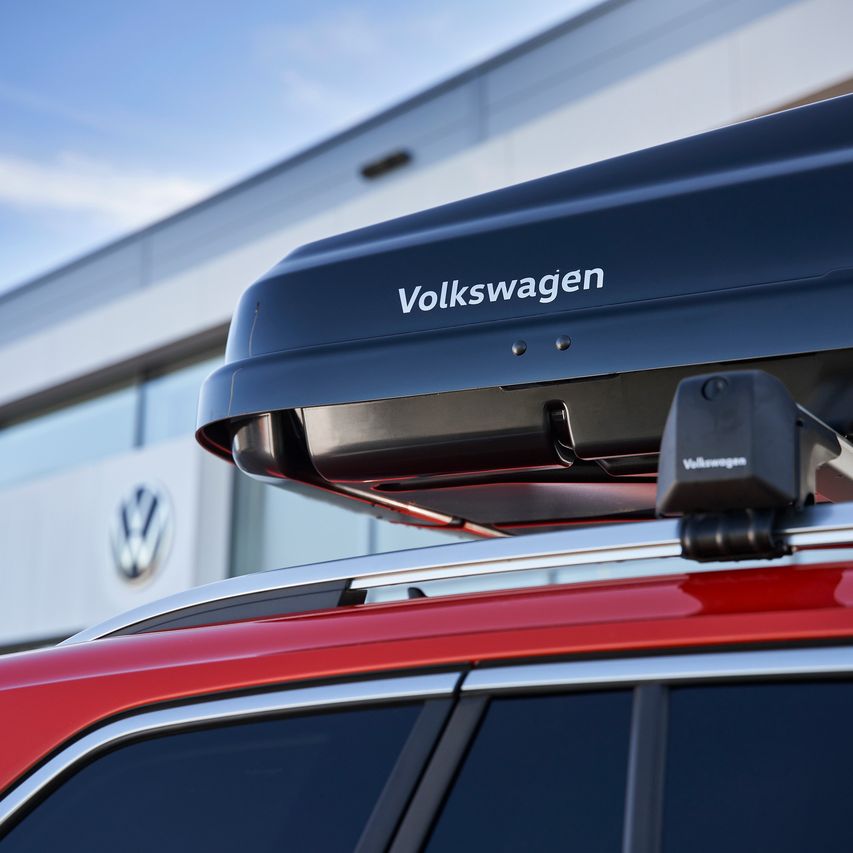 Eine schwarze Dachbox mit Volkswagen Schriftzug am Dach eines Volkswagen