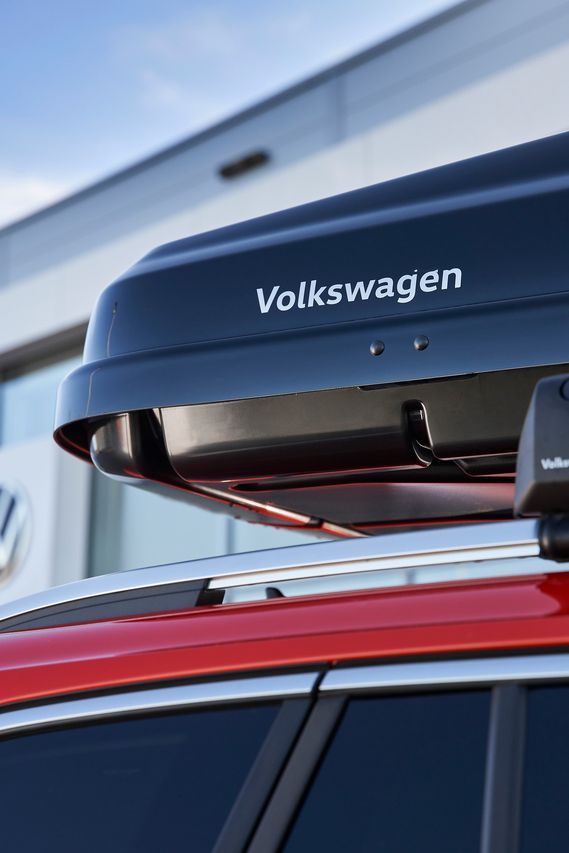 Eine schwarze Dachbox mit Volkswagen Schriftzug am Dach eines Volkswagen