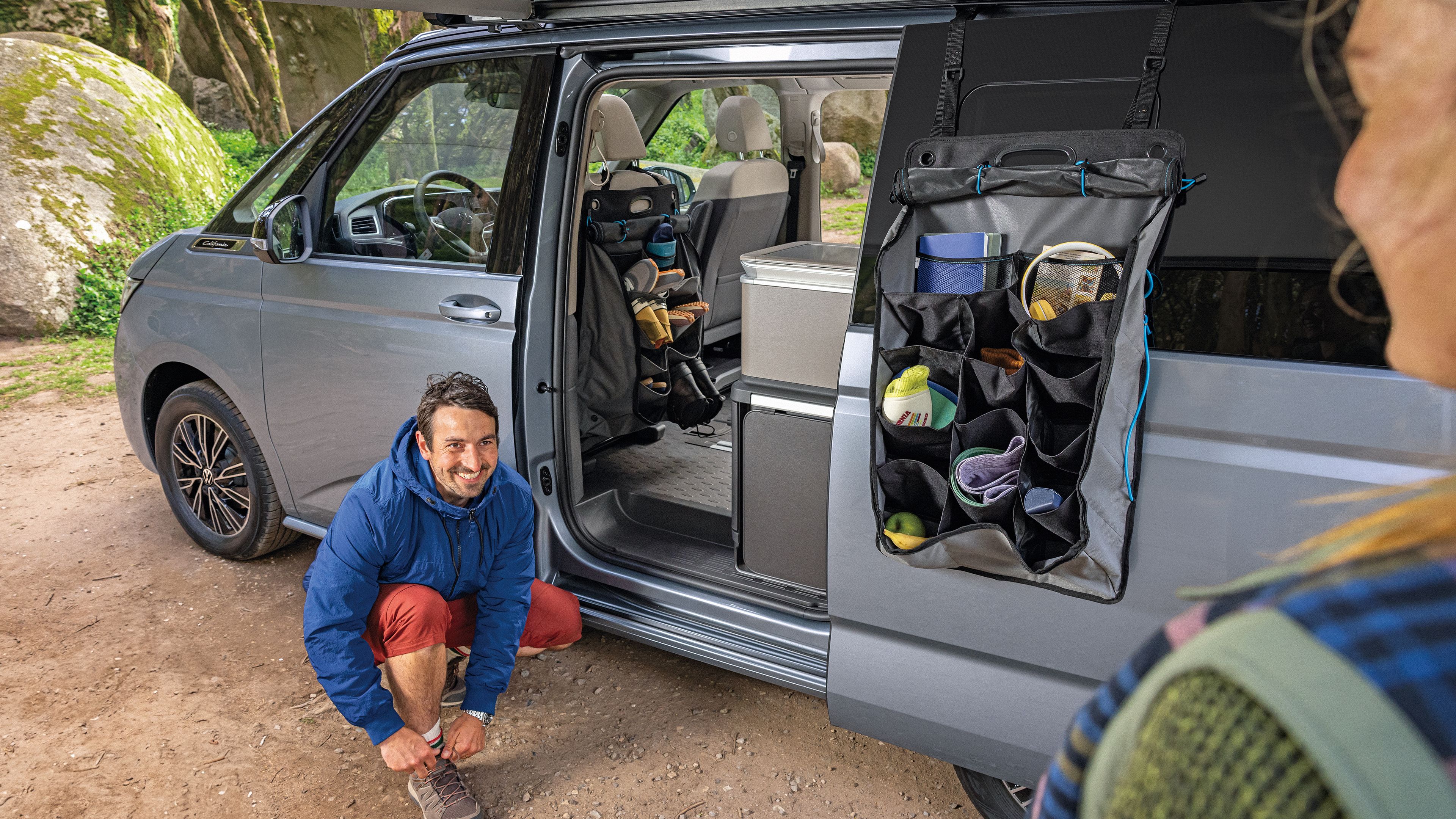 Ein Mann wechselt seine Schuhe, die er praktisch in seinem VW California verstauen konnte