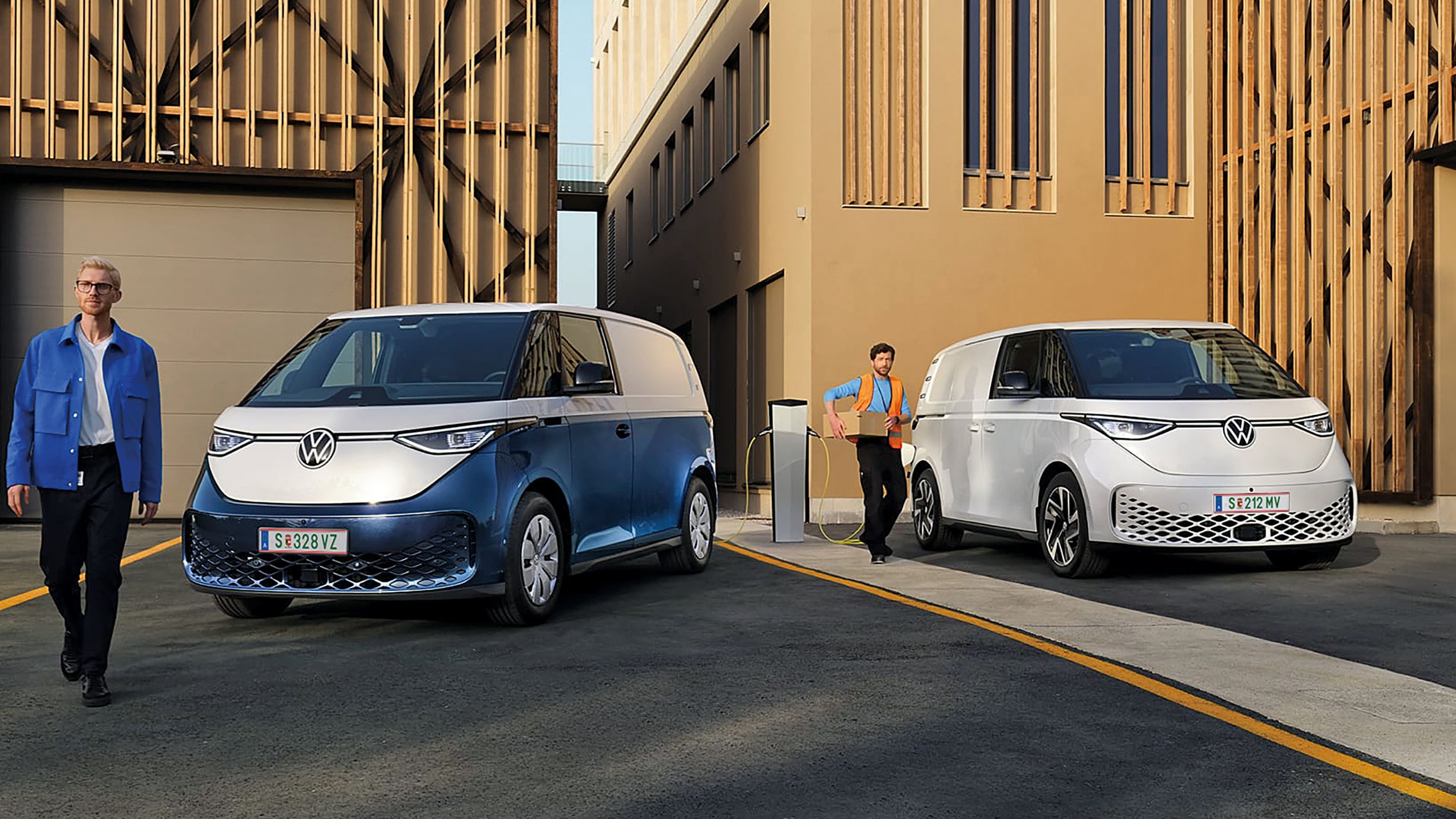 Heck des neuen VW T7 Multivan Style ist zu sehen und ein Mann und eine Frau spazieren vorbei