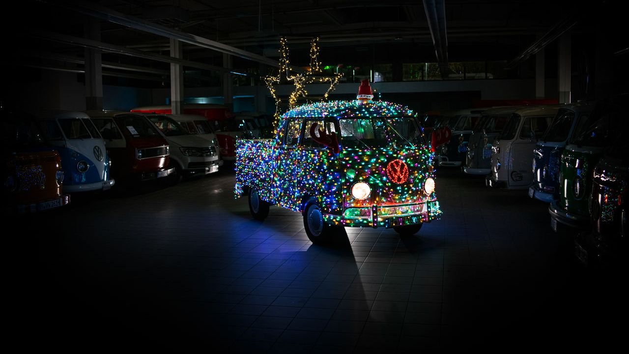 Ein Volkswagen Bulli  zur Weihnachtszeit verziert mit vielen bunten Lichtern.
