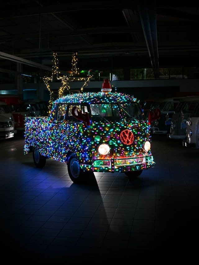 Ein Volkswagen Bulli  zur Weihnachtszeit verziert mit vielen bunten Lichtern.