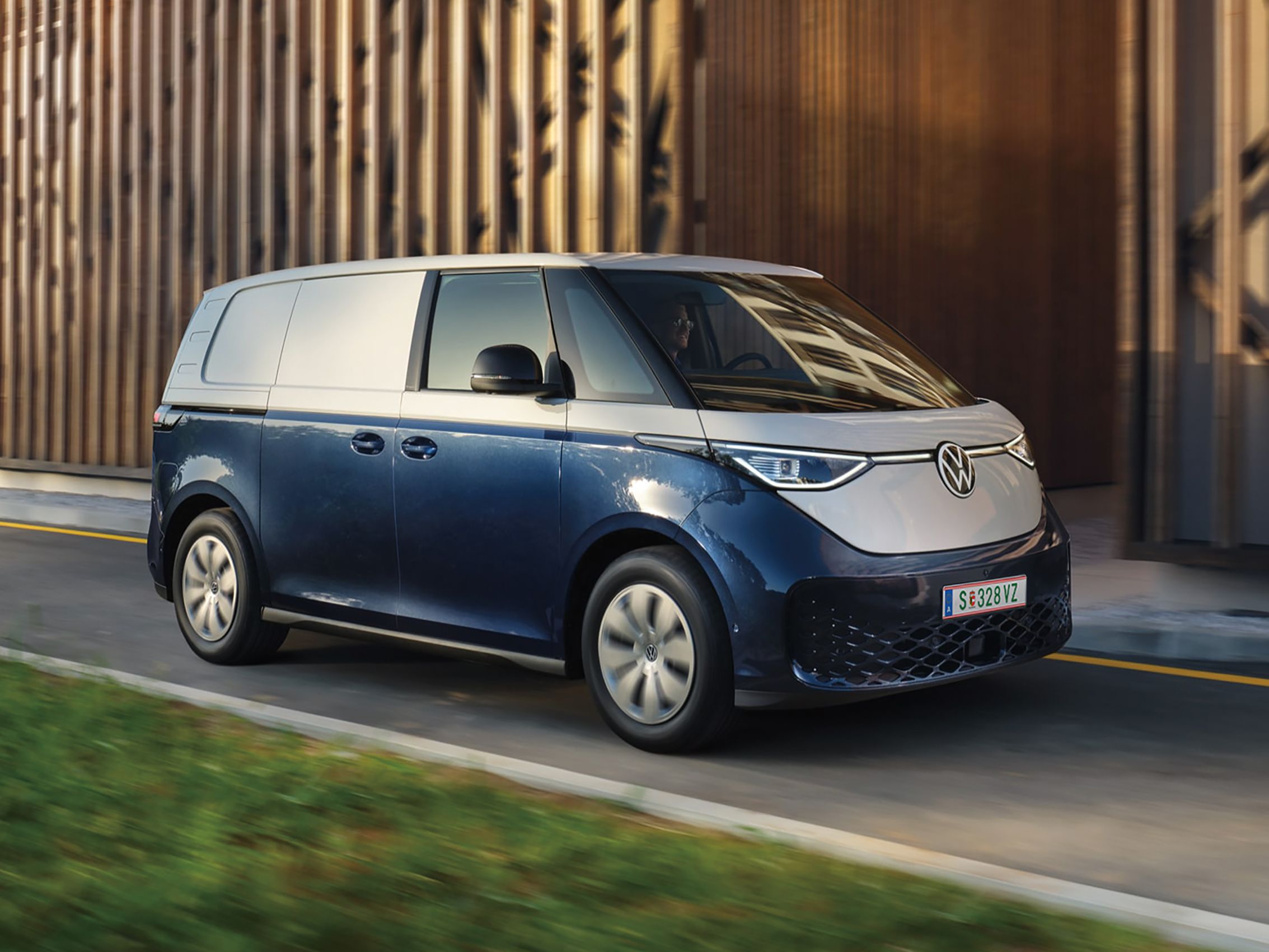 Blauer ID. Buzz fährt entlang einer einspurigen Straße