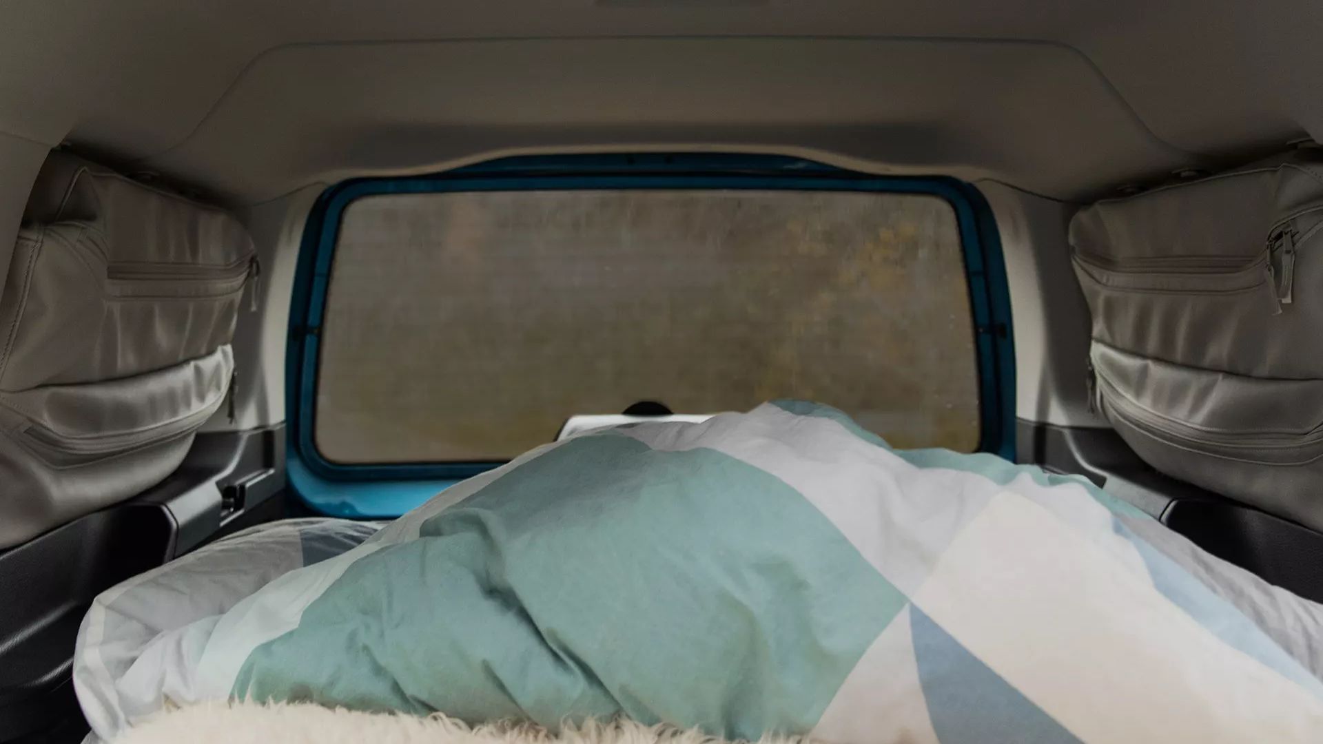 VW Caddy California verdunkelte Scheibe mit Innenraum und bezogenem Bett