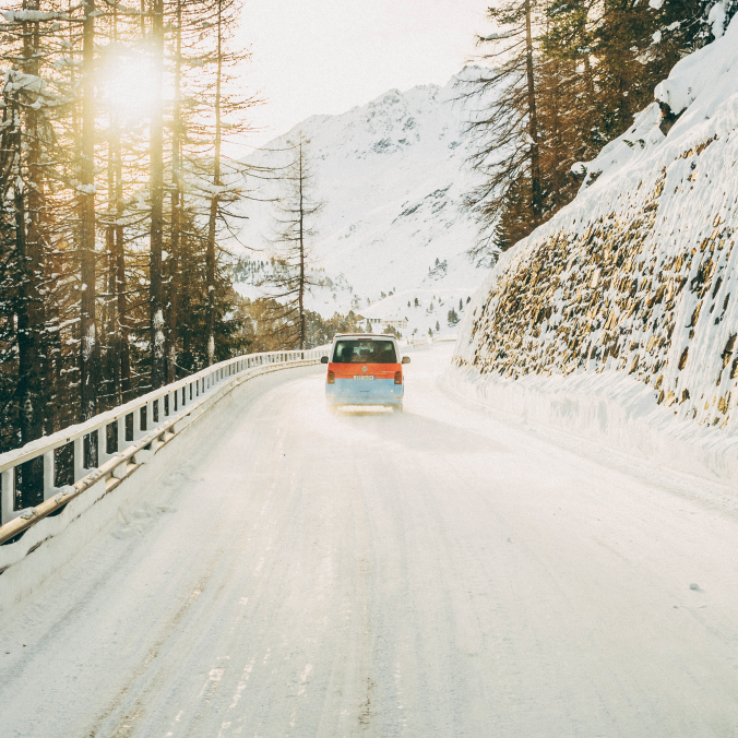 Ein Volkswagen Nutzfahrzeug fährt eine winterliche Straße entlang