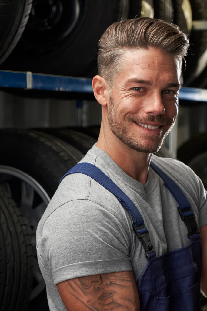 Ein VW Techniker vor Regalen mit Volkswagen Reifen und Rädern