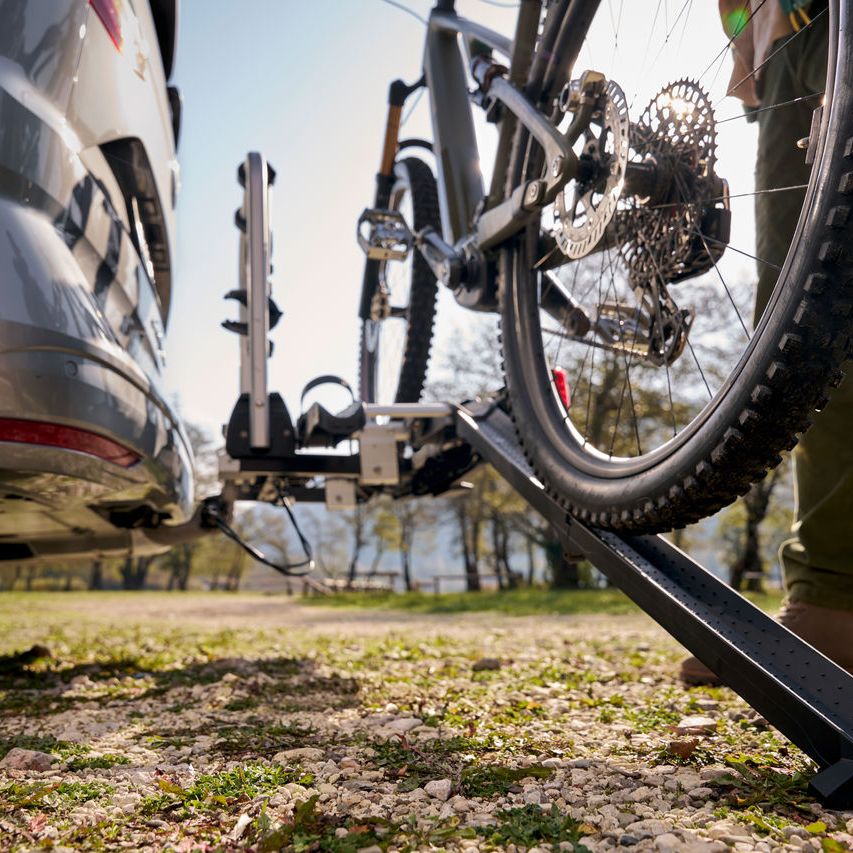 Ein Mann befestigt ein Fahrrad an einem Volkswagen Fahrrad Heckträger.