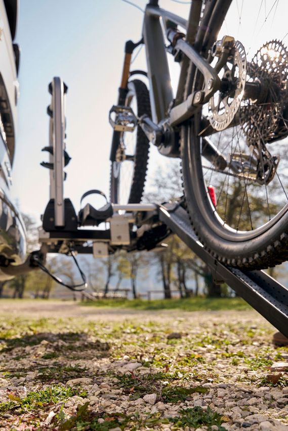 Ein Mann befestigt ein Fahrrad an einem Volkswagen Fahrrad Heckträger.
