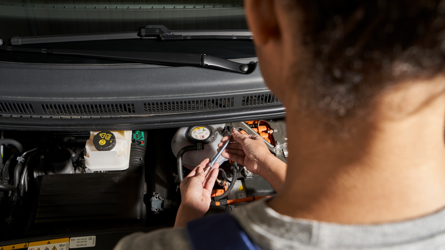 Eine Volkswagen Technikerin wechselt die Zündkerzen.