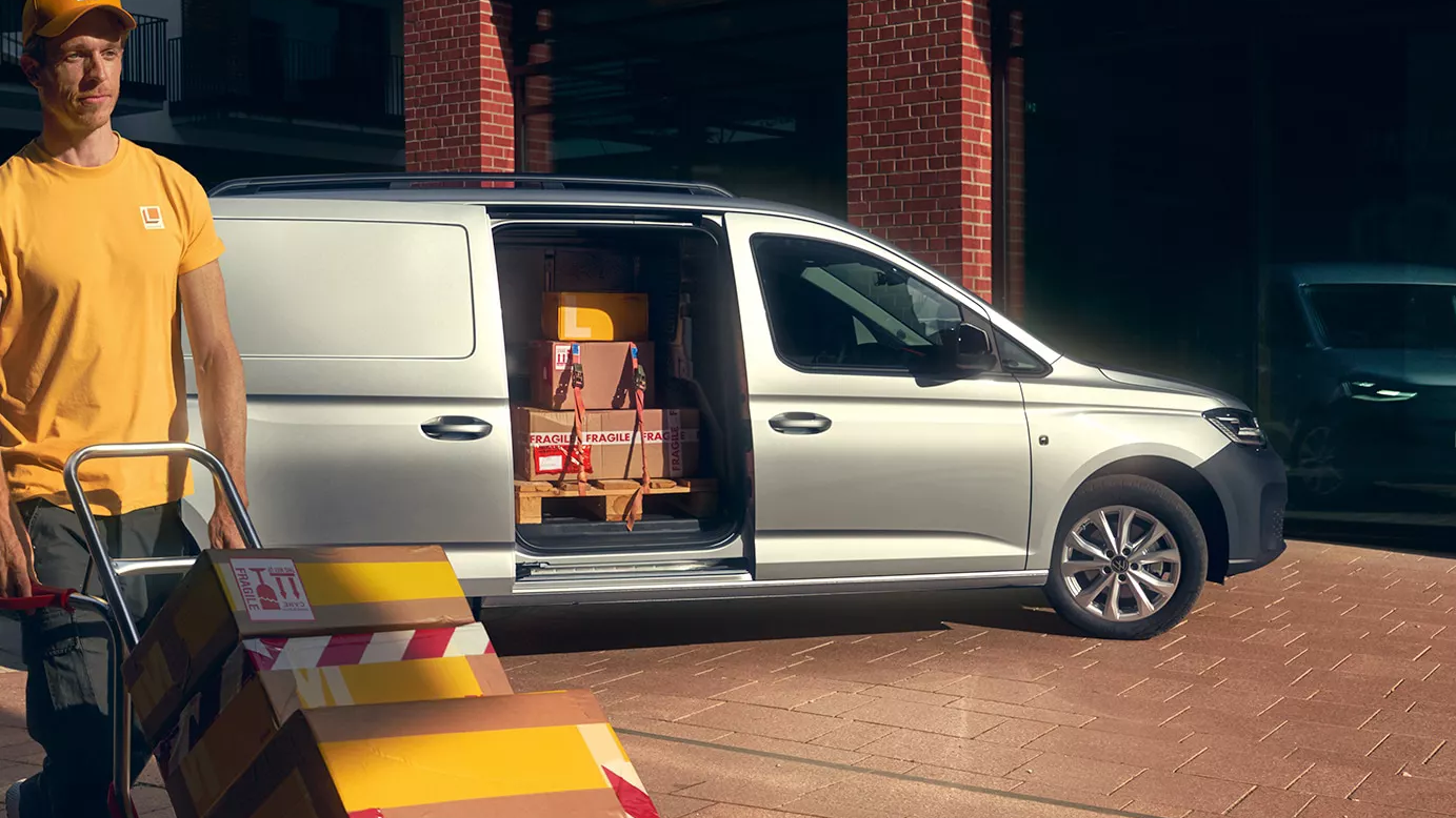 Mann entlädt einen silbernen Caddy Cargo