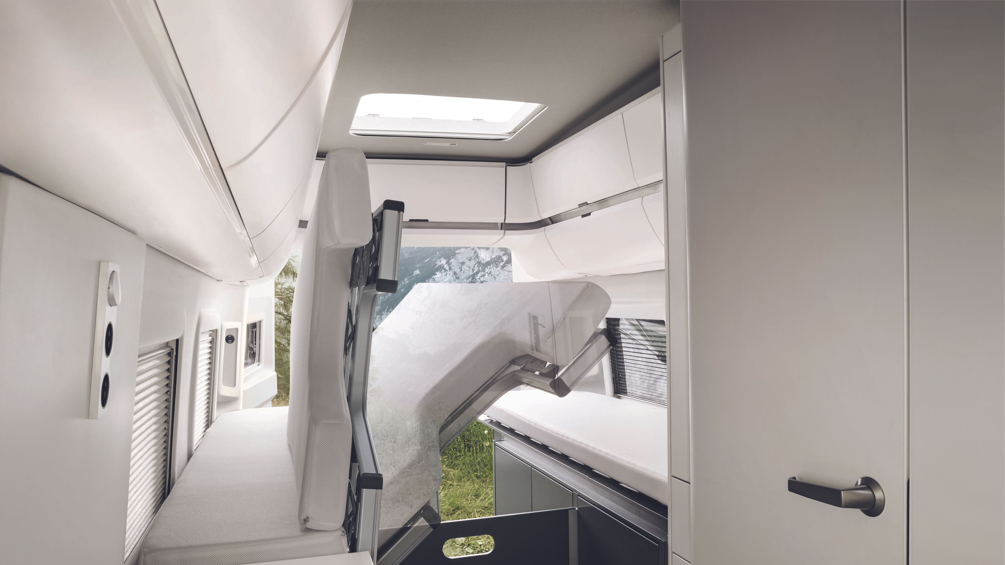 Ein Blick ins Heck des VW Grand California 680. Das Längsbett ist hochgeklappt. Darunter ist der großzügige Stauraum zu sehen.