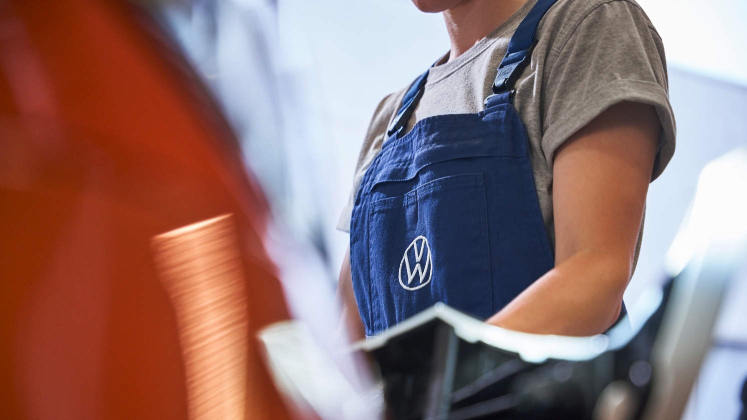 Fokusansicht des Volkswagen Logos der Arbeitskleidung einer Volkswagen Technikerin