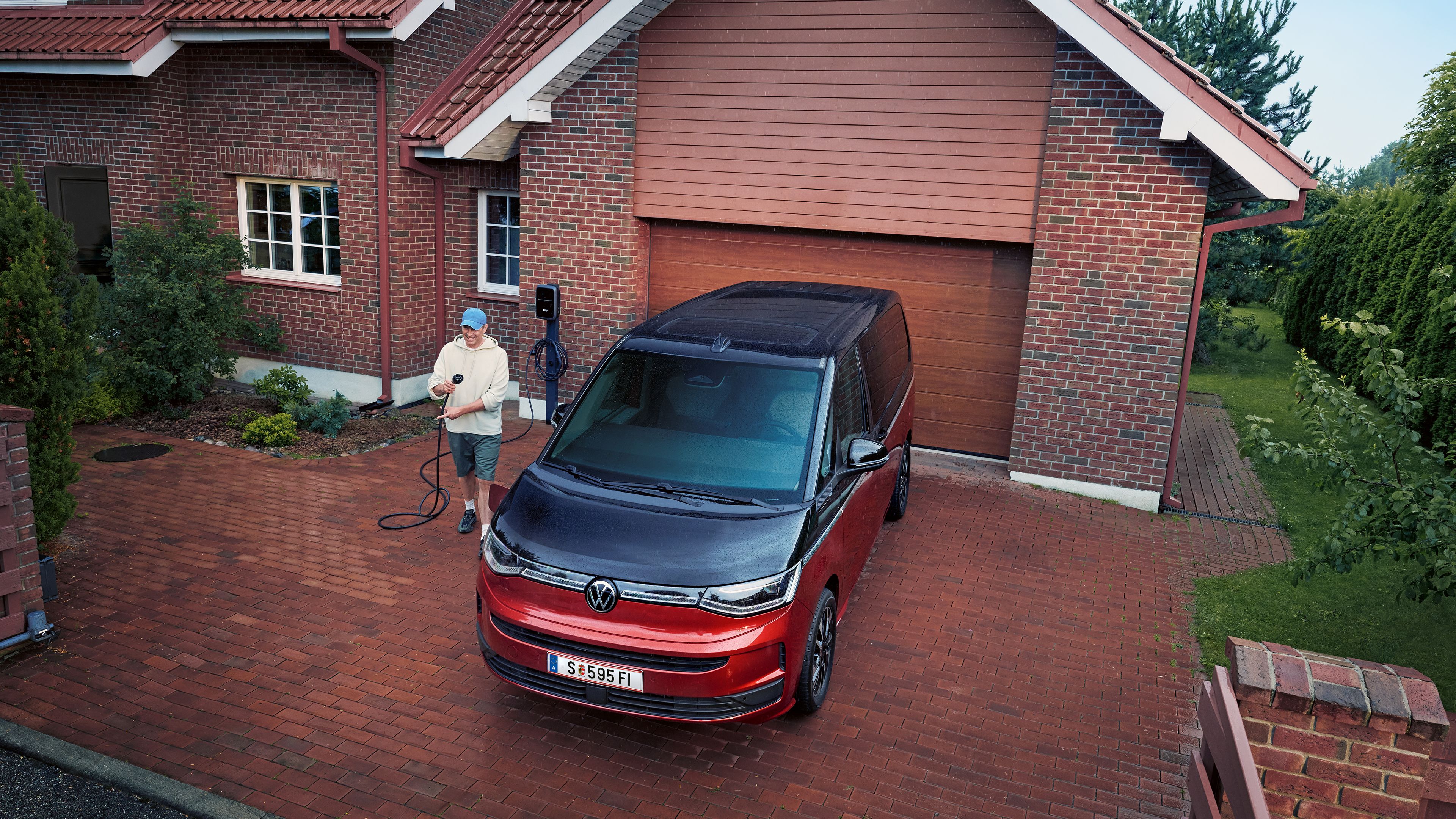 Der Multivan eHybrid 4MOTION wird vor Haus geladen.