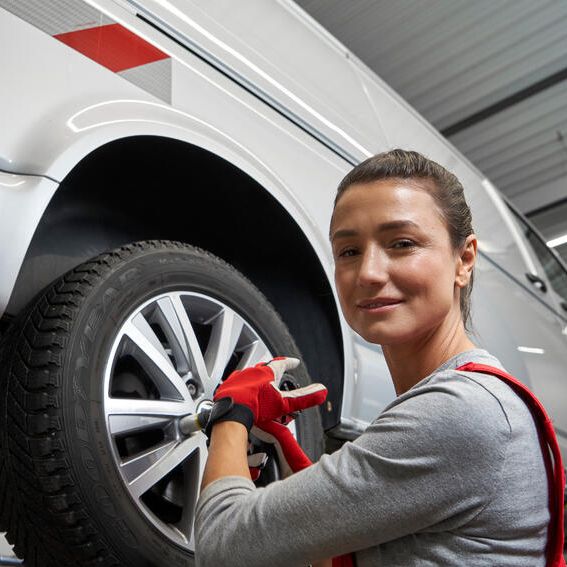 Eine Volkswagen Technikerin beim Reifenwechsel