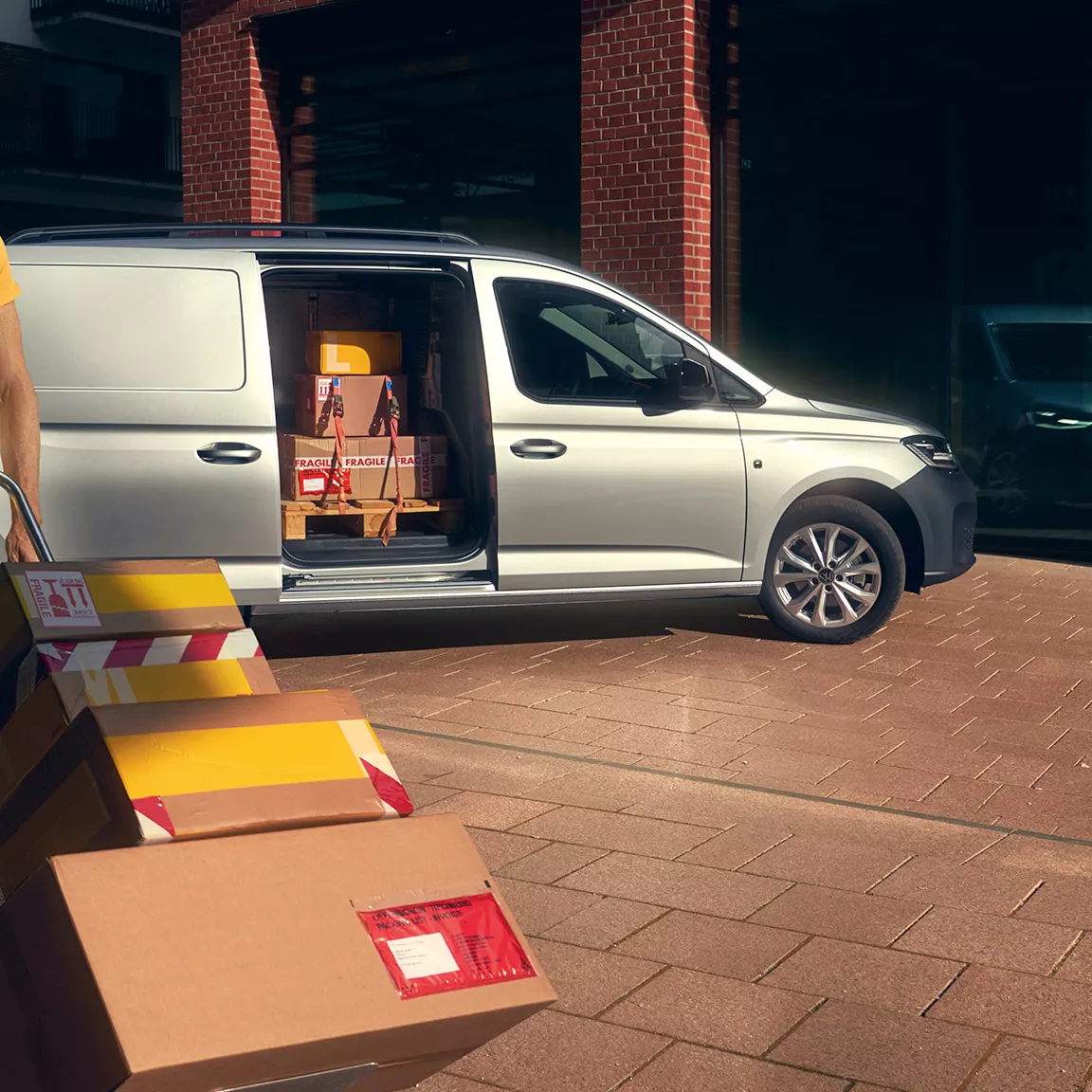 Mann entlädt einen silbernen Caddy Cargo