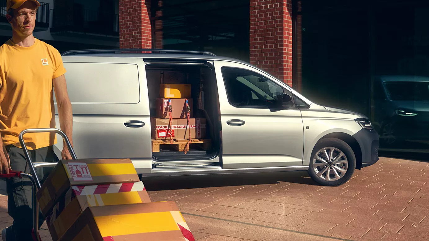 Mann entlädt einen silbernen Caddy Cargo