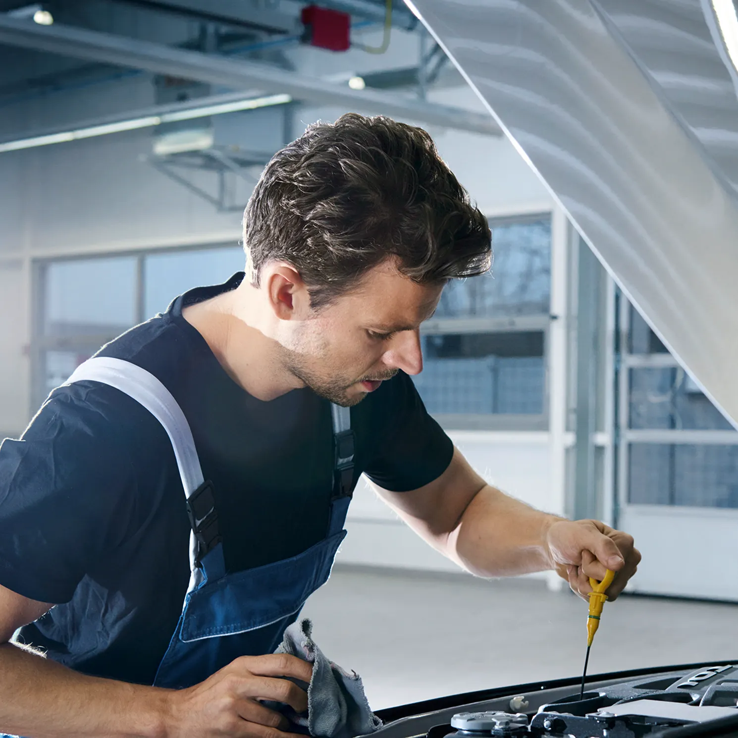 Ein Volkswagen Techniker beim Messen des Ölstandes
