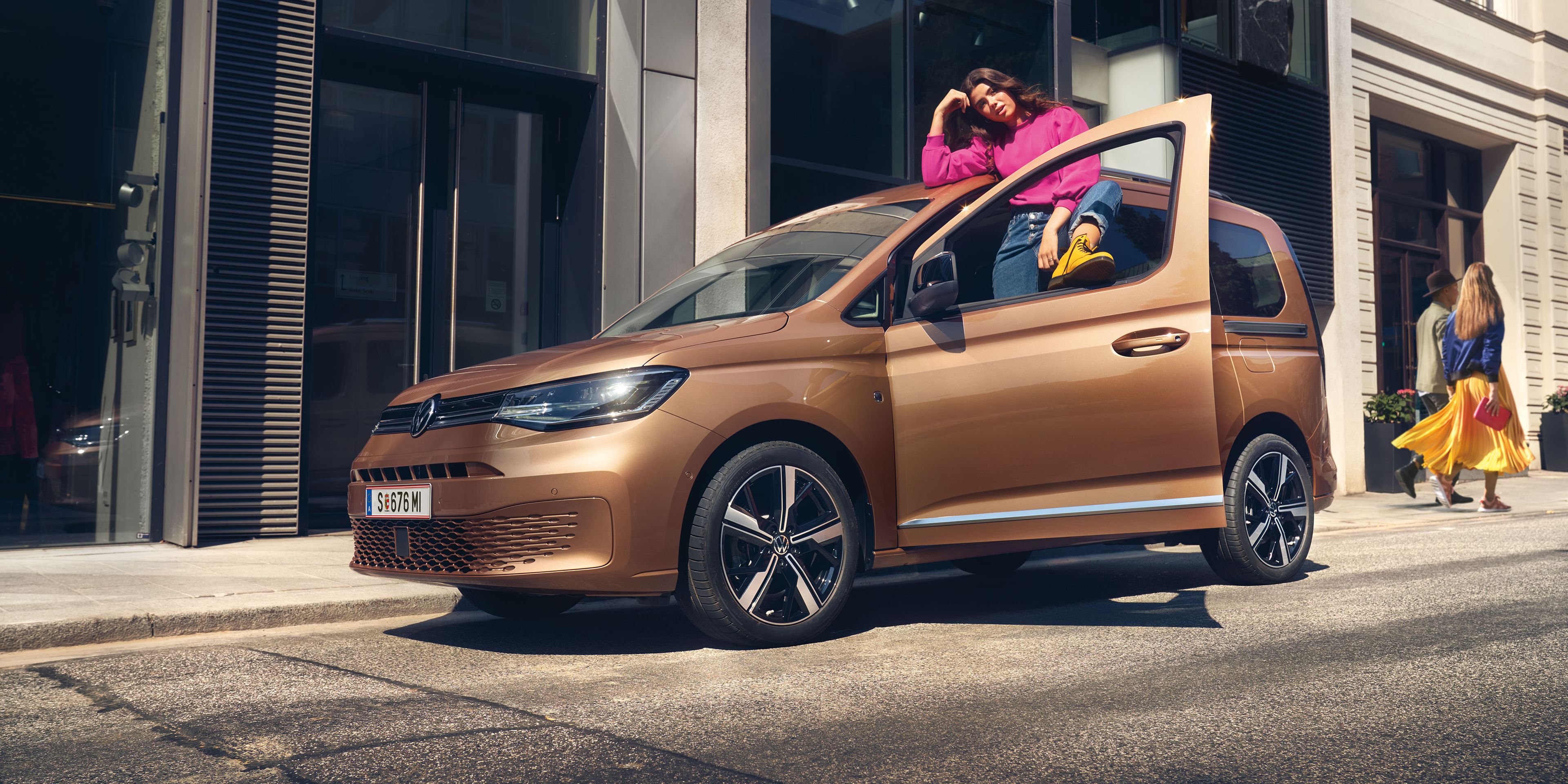 Ein VW Caddy in Copper Bronze steht auf Straße