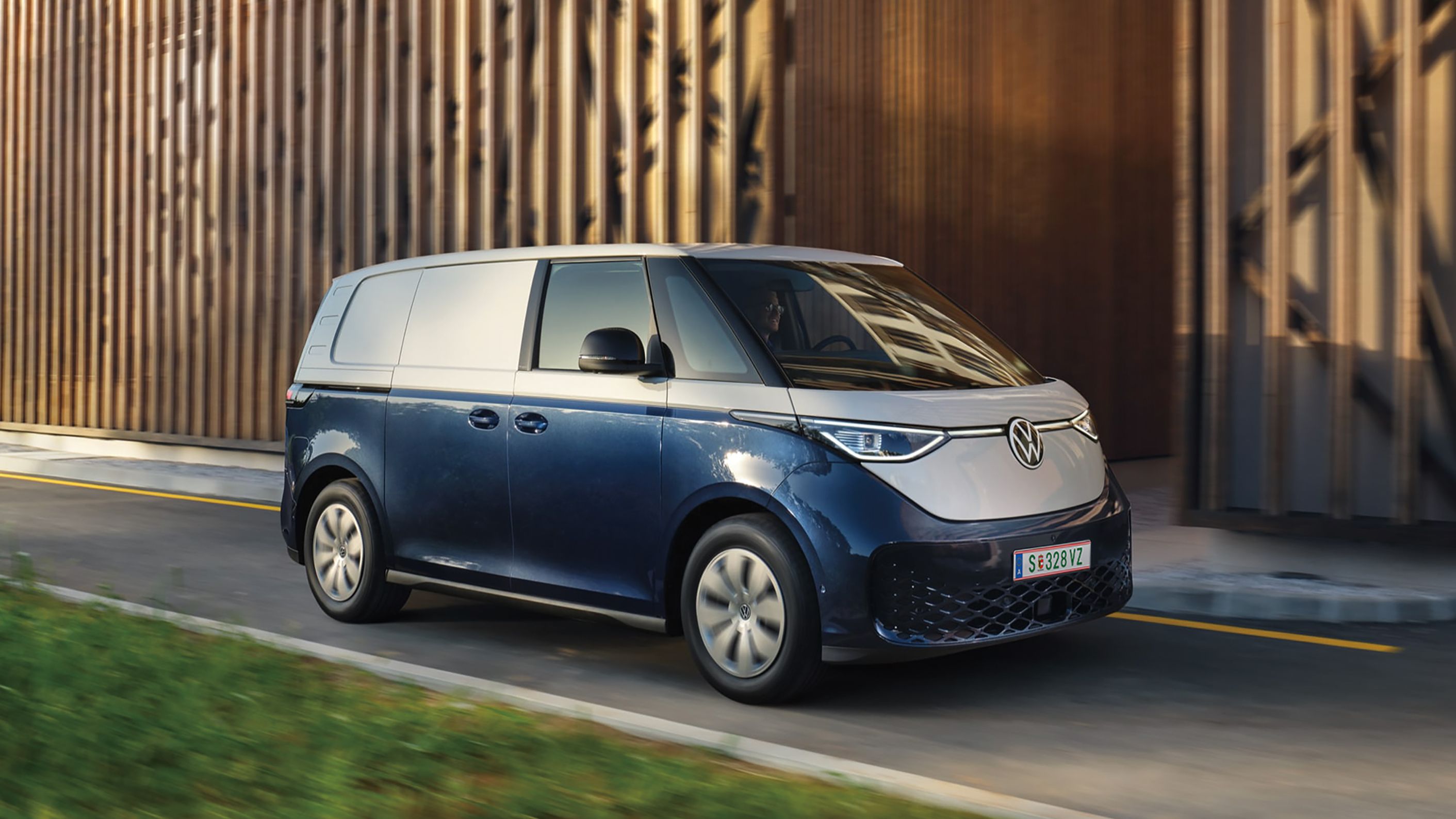 Blauer ID. Buzz fährt entlang einer einspurigen Straße