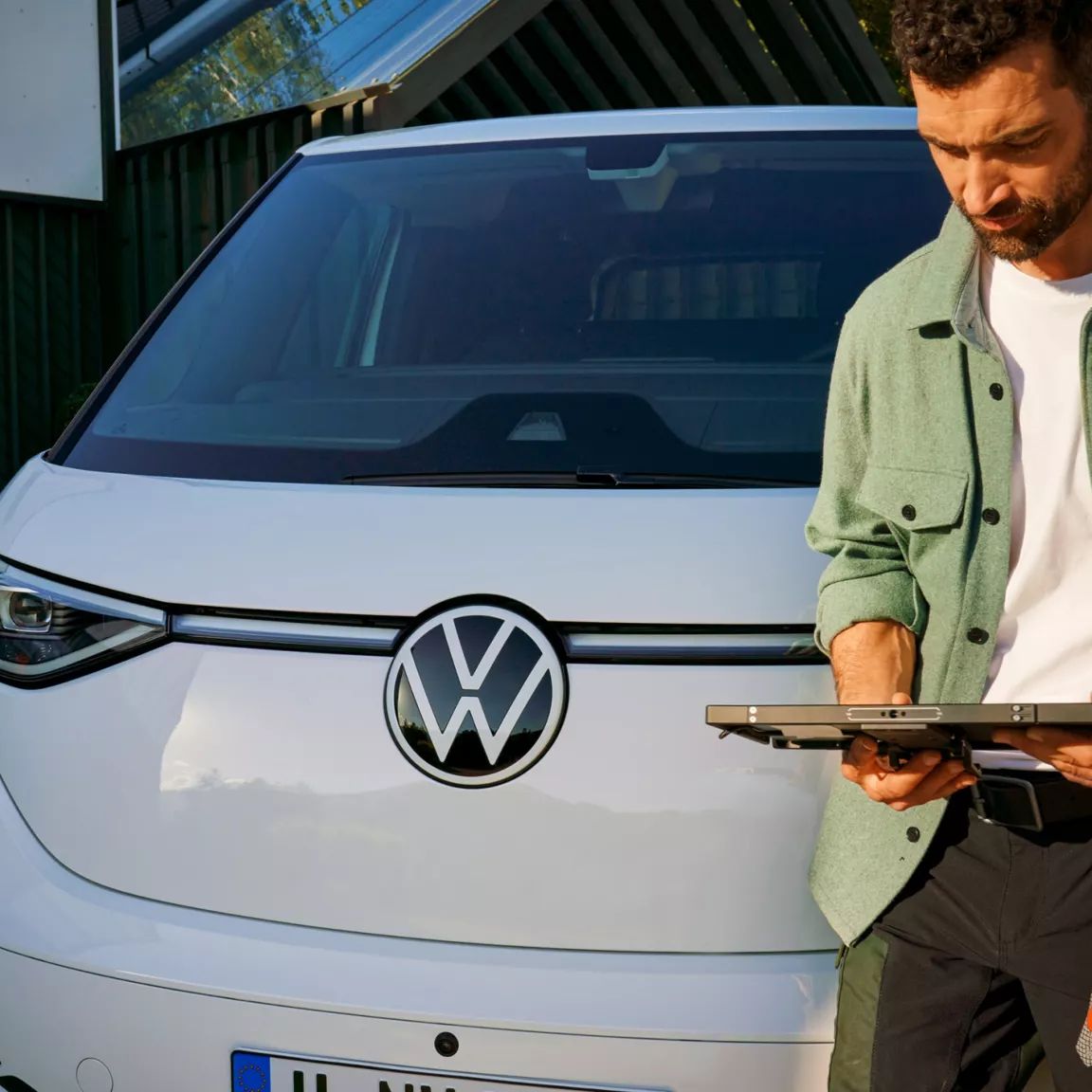 Mann schaut auf Tablet, steht vor ID. Buzz