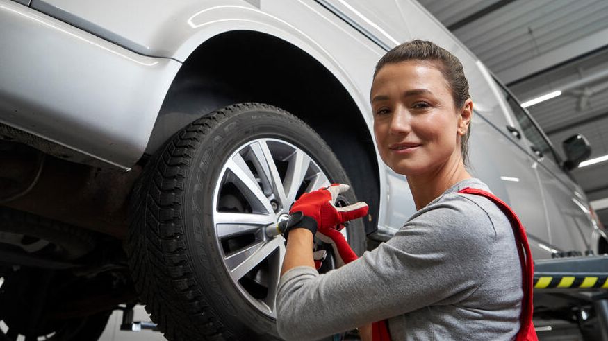 Eine Volkswagen Technikerin beim Reifenwechsel