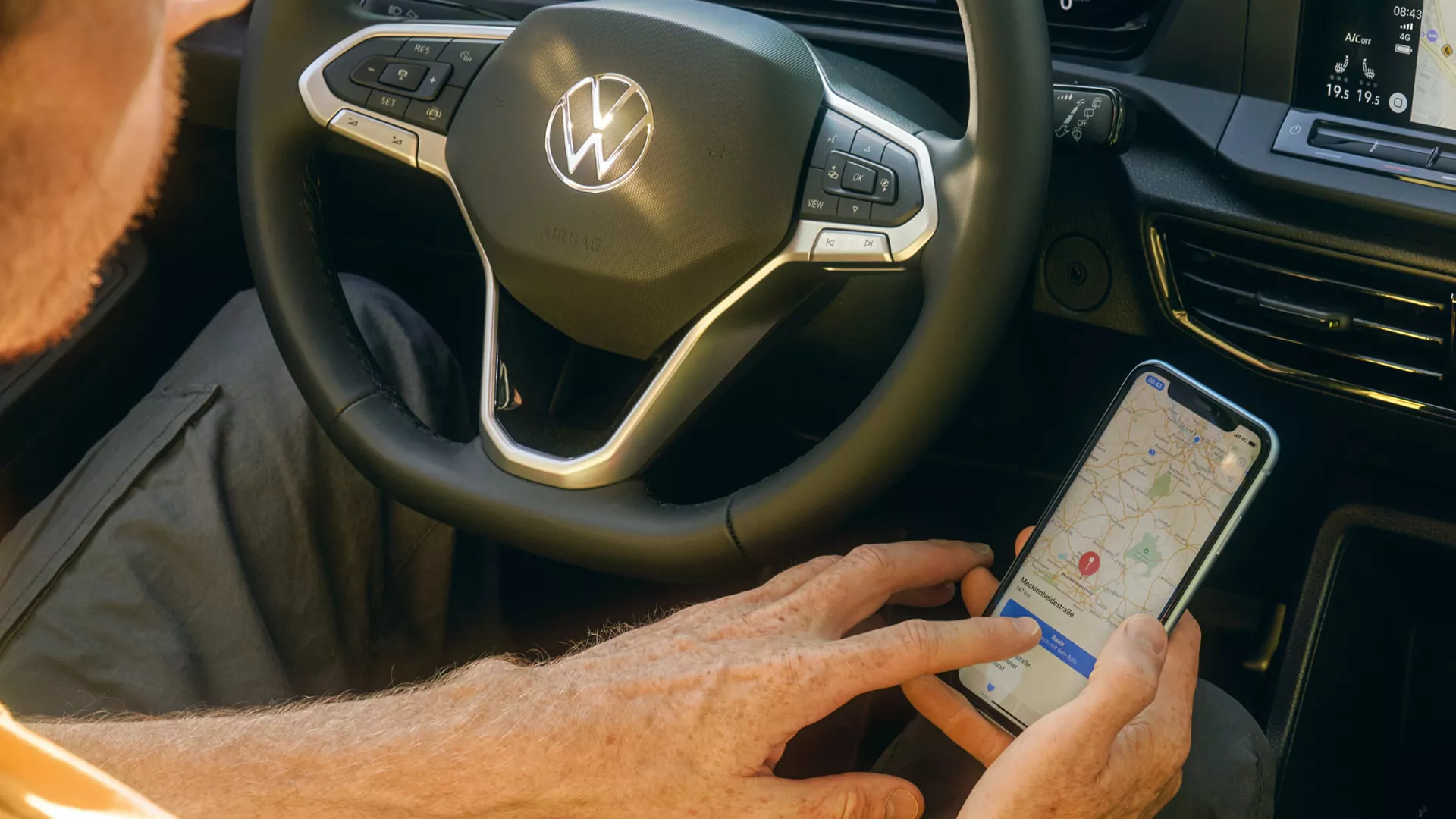 Fahrer eines Caddy Cargos verbindet das Navigationssystem seines Handys mit dem Caddy