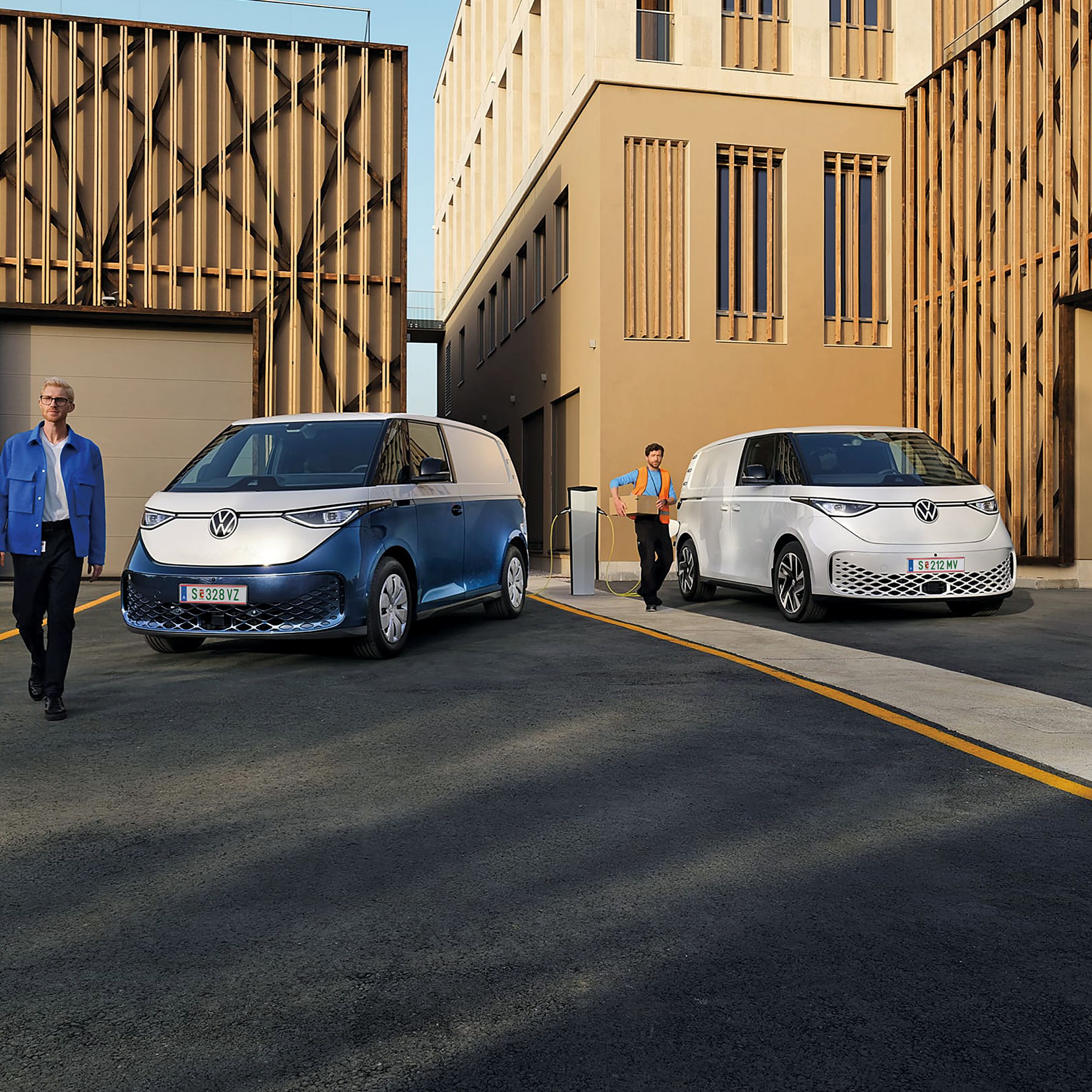 Heck des neuen VW T7 Multivan Style ist zu sehen und ein Mann und eine Frau spazieren vorbei