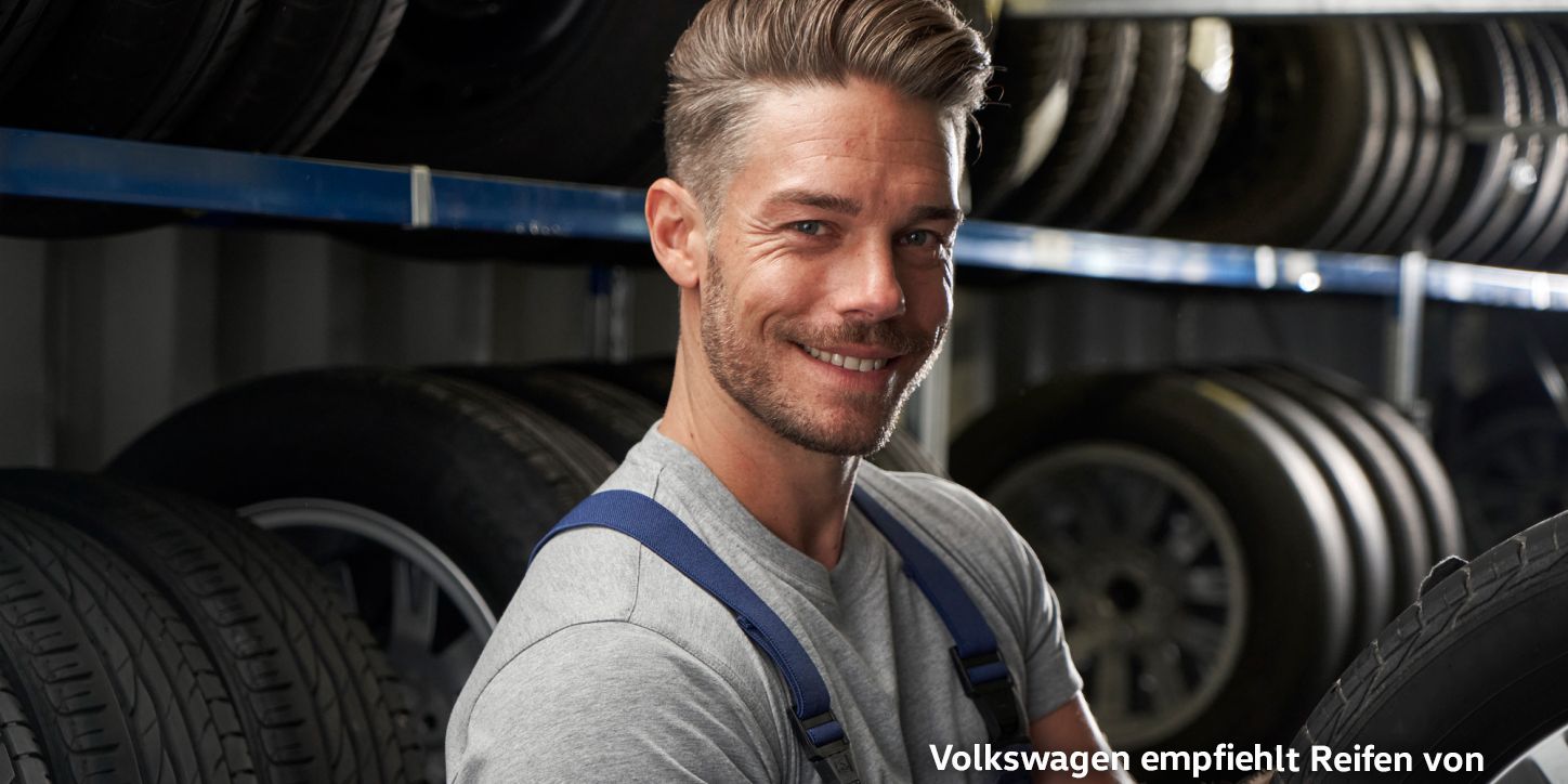 Ein Volkswagen Service Techniker schlichtet Winterkompletträder in ein Regal