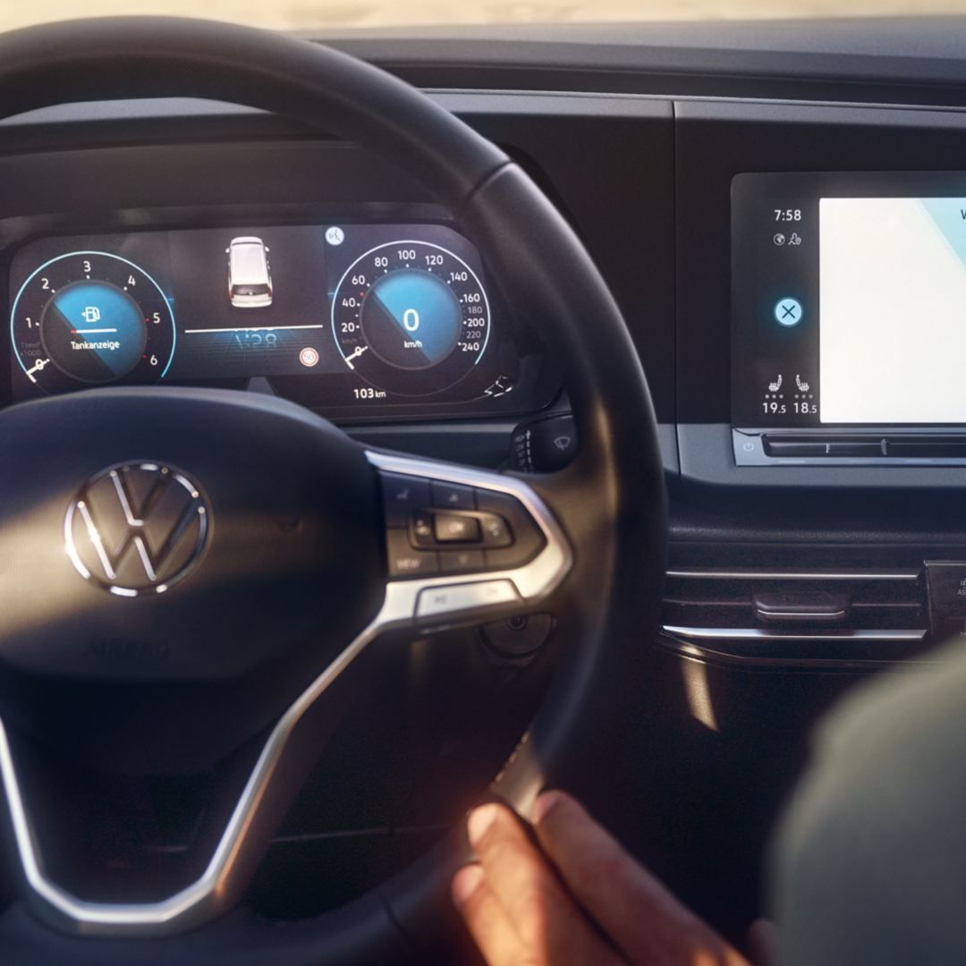 Ein Mann sitzt am Beifahrersitz seines VWs und benutzt die Sprachsteuerung