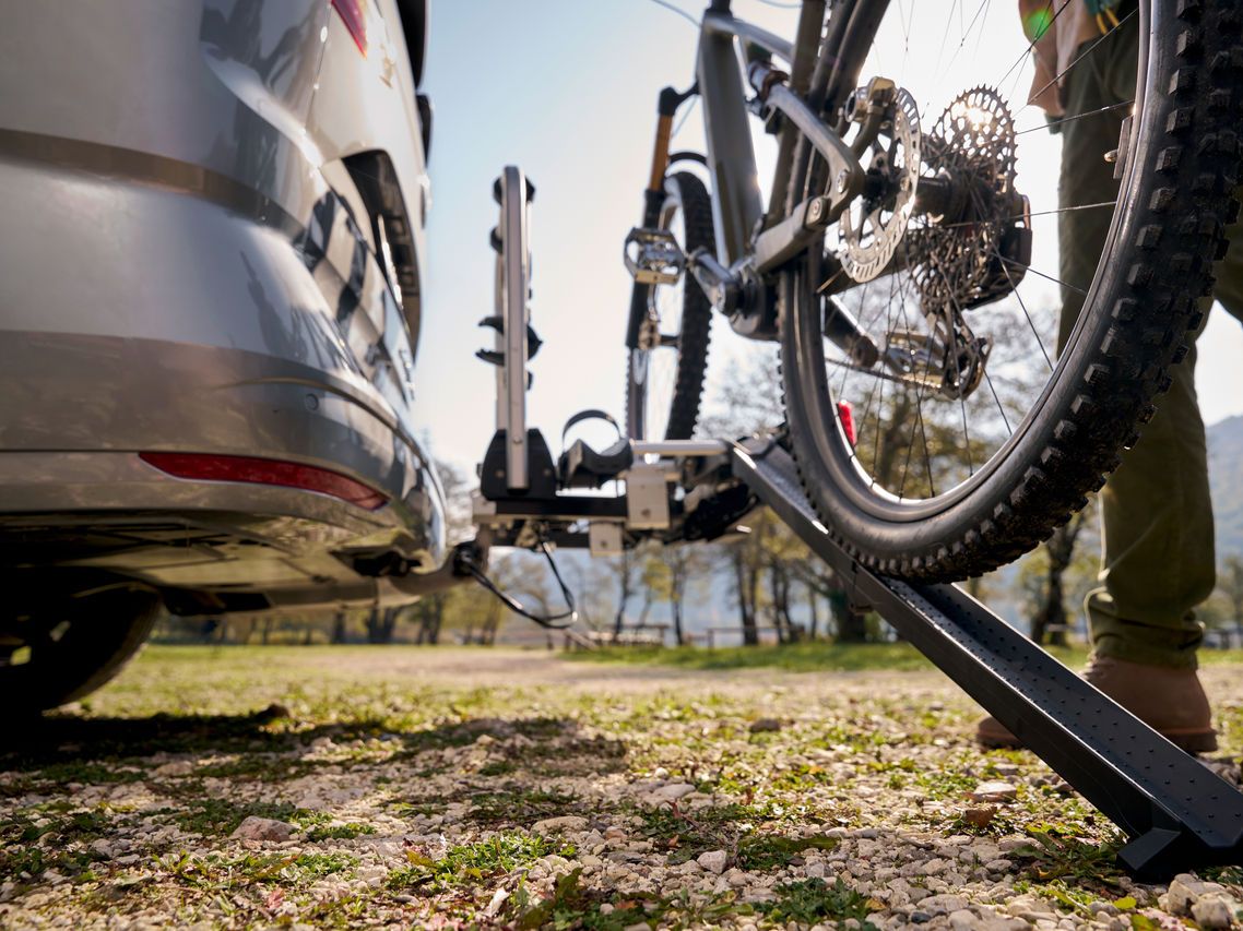 Ein Mann befestigt ein Fahrrad an einem Volkswagen Fahrrad Heckträger.