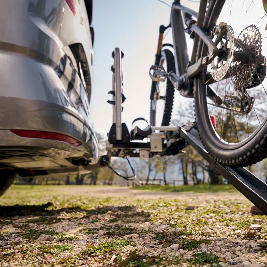 Ein Mann befestigt ein Fahrrad an einem Volkswagen Fahrrad Heckträger.