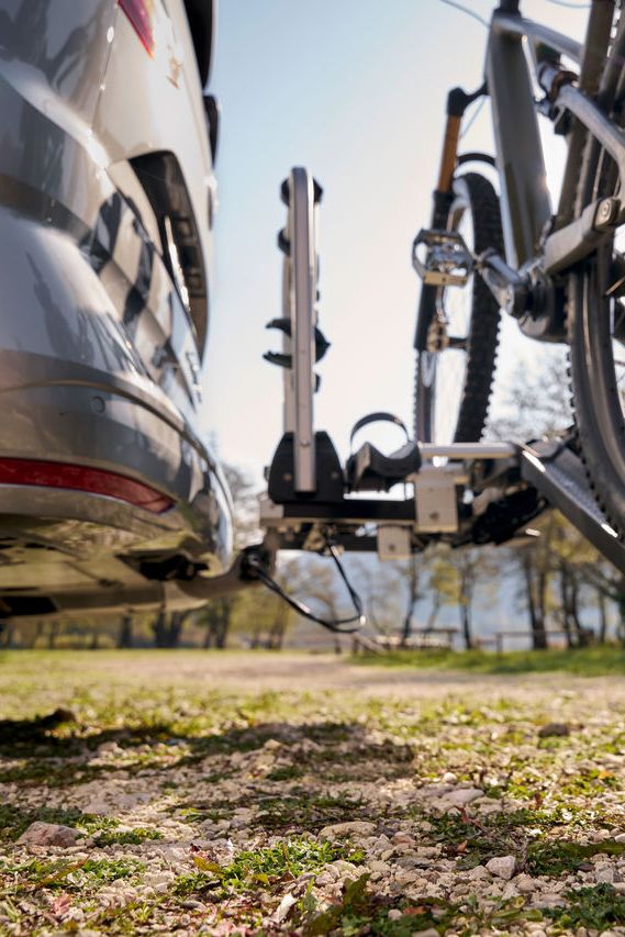 Ein Mann befestigt ein Fahrrad an einem Volkswagen Fahrrad Heckträger.