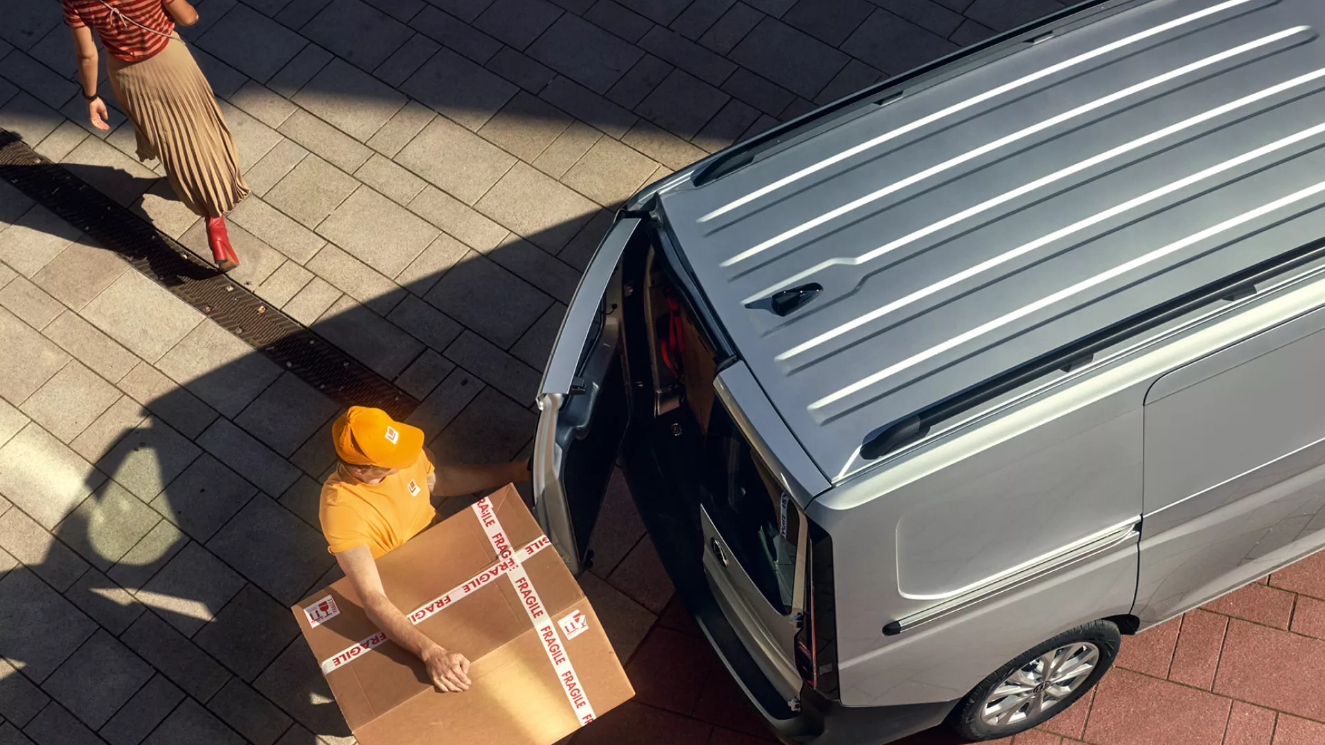Ein Mann schließt die Heckklappe eines Caddy Cargos, trägt dabei ein Paket