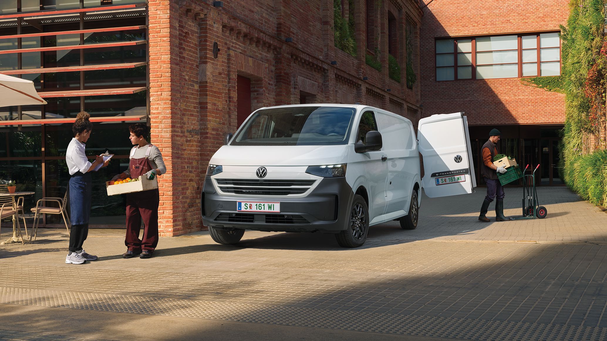 VW Transporter Kastenwagen in Weiß steht vor Haus