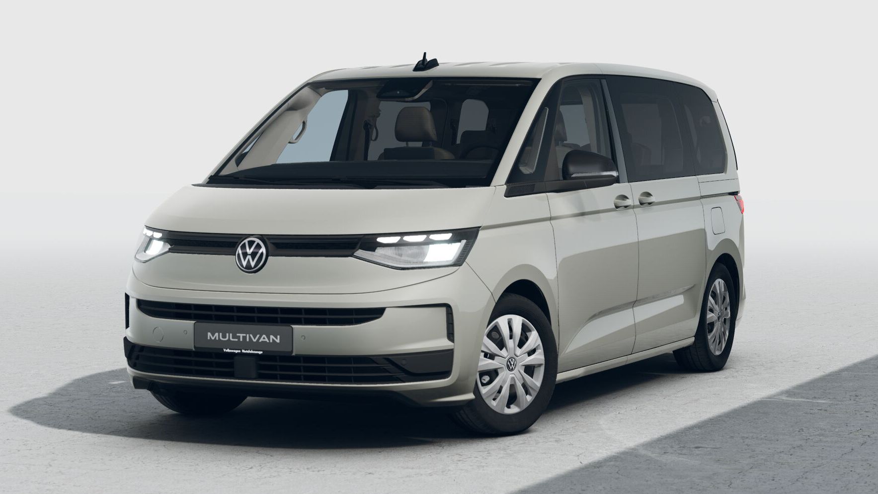 Beiger VW Multivan (neues Modell) in einer hellen Studio-Umgebung, leicht schräg von vorne fotografiert.  
Man sieht die markante LED-Lichtleiste vorne, große Seitenscheiben und Schiebetür auf der Beifahrerseite.  
Das Fahrzeug wirkt modern und geräumig, typisch für einen Familien- oder Shuttle-Van.